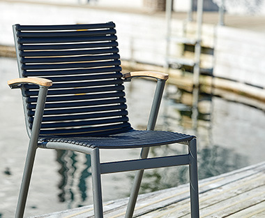 Ciemne krzesło ogrodowe z drewnianymi podłokietnikami 