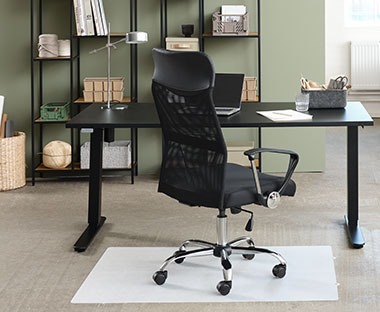 Czarne, duże biurko, przy którym stoi krzesło biurowe