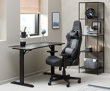 Czarne krzesło gamingowe przy regulowanym biurku 