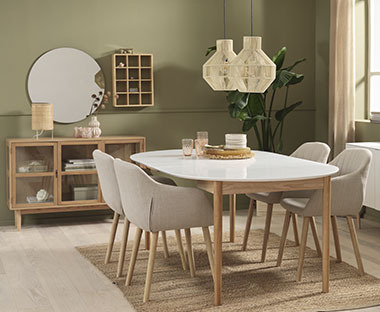 Jadalnia z dużym, owalnym stołem z białym blatem i drewnianymi nogami oraz 4 szarymi krzesłami z obiciem 