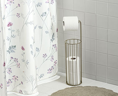Wielokolorowa zasłona prysznicowa i nowoczesny stojak na papier toaletowy