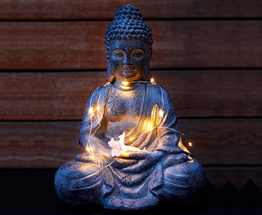 Figurka siedzącego buddy podświetlona lampkami 