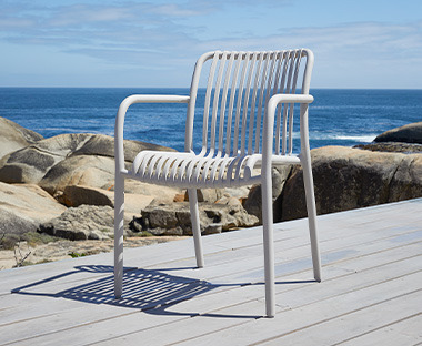Jasne krzesło plastikowe stojące na tarasie nad brzegiem morza