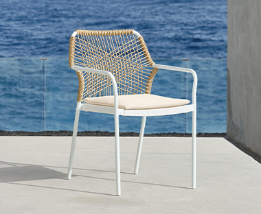 Białe, nowoczesne krzesło z plecionymi plecami na tarasie