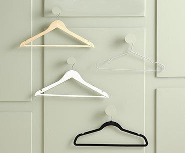Różne rodzaje wieszaków na ubrania zawieszone na drzwiach szafy