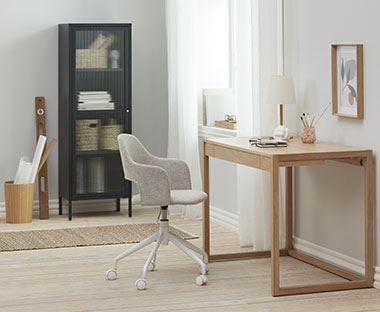 Jasne, drewniane biurko i krzesło biurkowe na kółkach z szarym siedziskiem 
