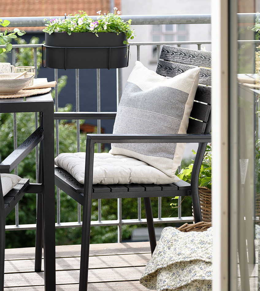 Czarne krzesło ogrodowe z poduszkami na balkon