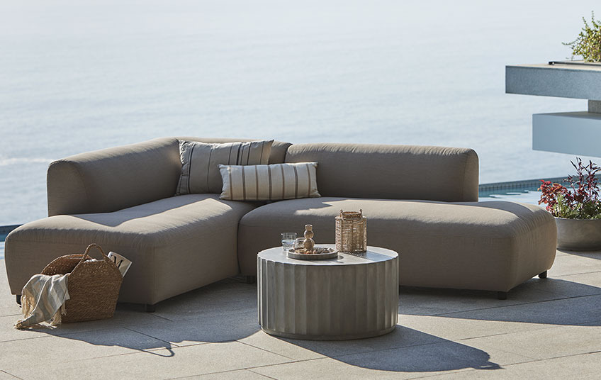 Sofa wypoczynkowa na każdą pogodę w kolorze beżowym i stolik na balkonie 