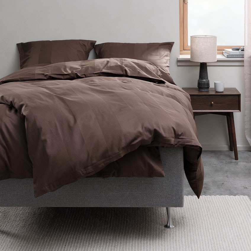 Czekoladowo-brązowa poszwa na kołdrę i bawełniana pościel na łóżku w sypialni 