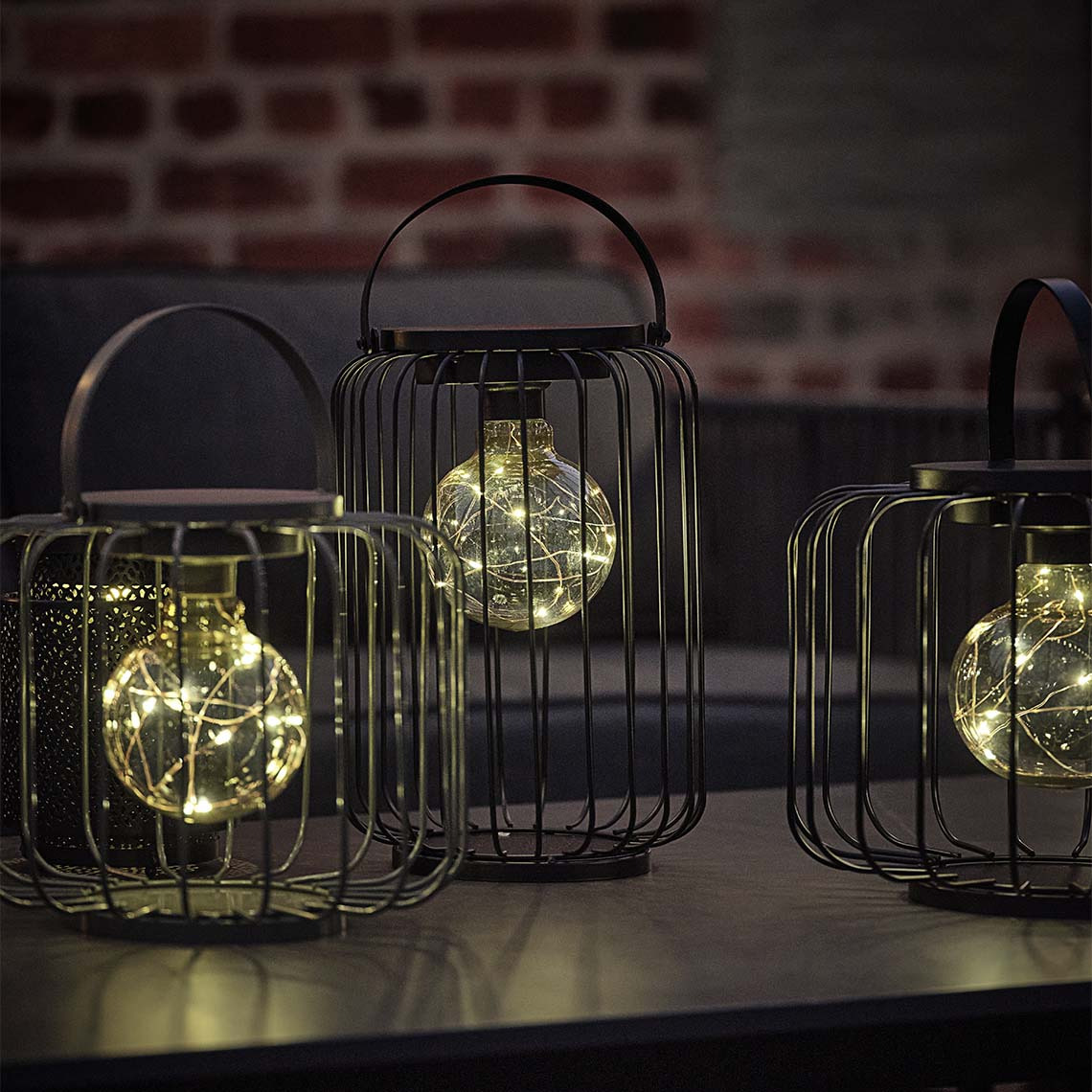 Lampa akumulatorowa GLENTE jest dostępna w dwóch rozmiarach Zewnętrzna lampa akumulatorowa z otwartą ramą z drutu stalowego i dekoracyjną żarówką LED
