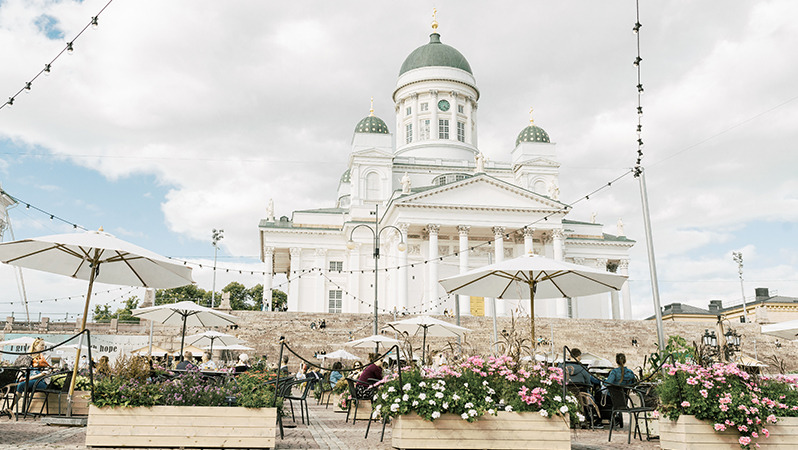 Publiczny plac w Helsinkach ze stolikami kawiarnianymi i krzesłami firmy JYSK