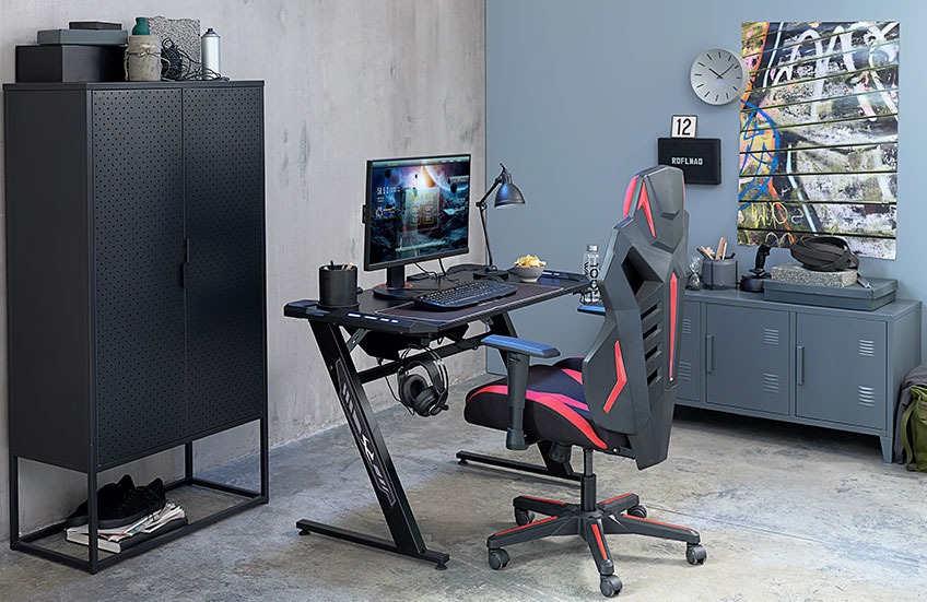 Pokój gracza w ciemnych kolorach z regulowanym biurkiem i krzesłem 