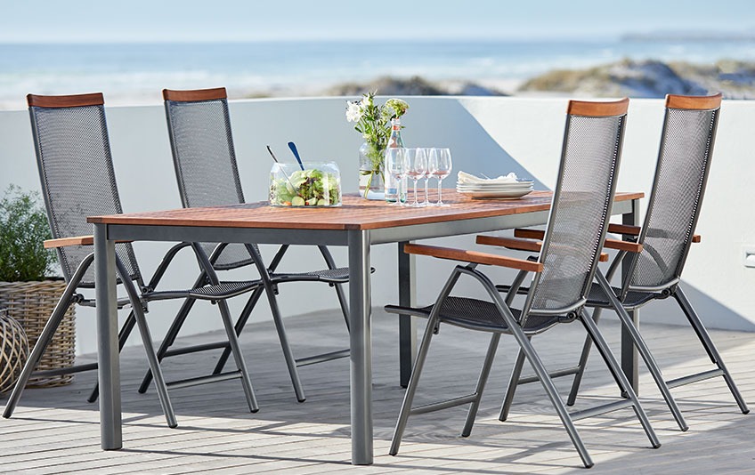 Garden furniture out of metal and hardwood on a patio