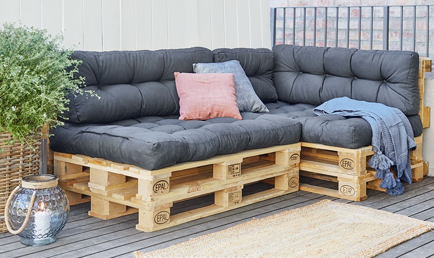 Pallet sofa with cushions and throw on a patio 