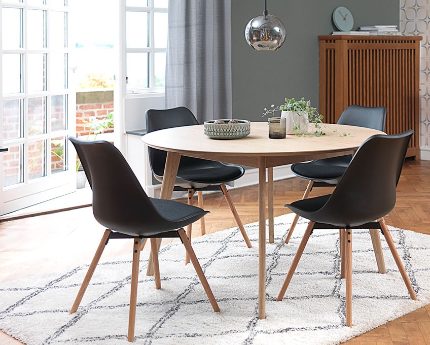 Okrągły stół i czarne krzesła do jadalni na dywanie w jadalni