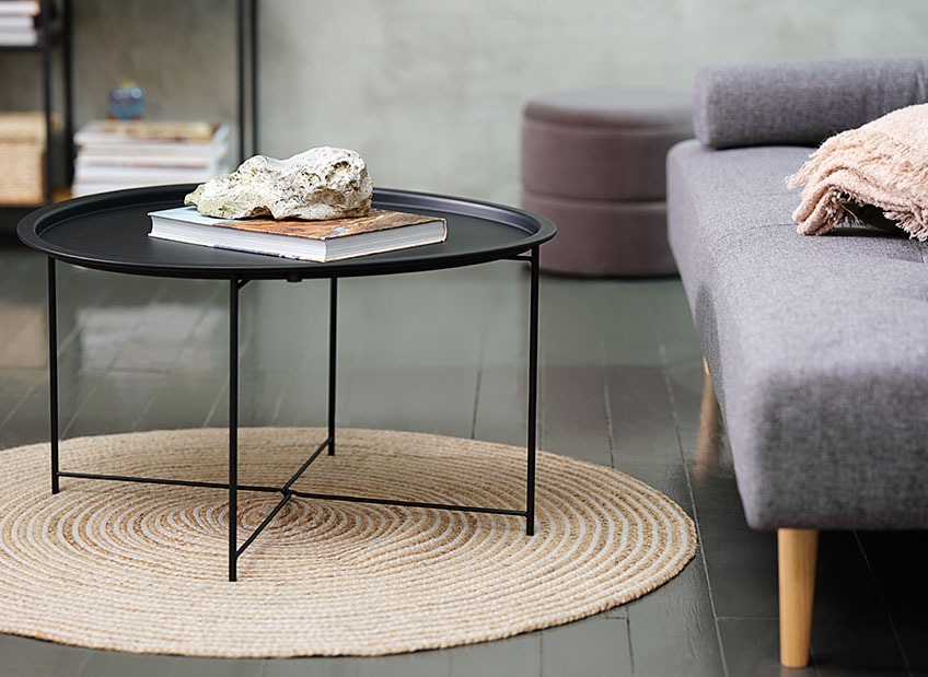 Stolik kawowy na okrągłym dywanie przed sofą