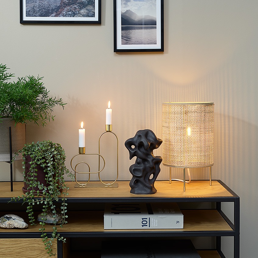 Doniczki, sztuczne rośliny, świecznik, ozdoba i lampa stołowa na szafce TV