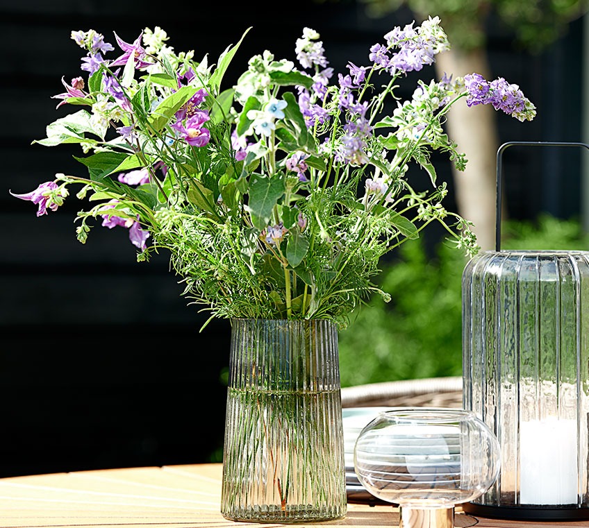 Szklany wazon na stole ogrodowym
