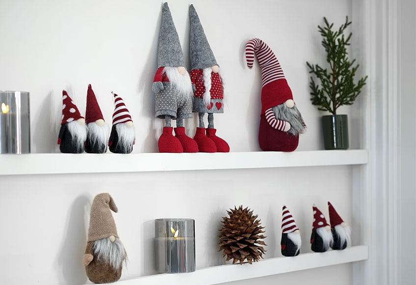 czerwone i beżowe skandynawskie elfy, na półce z mini choinkami i świeczkami 