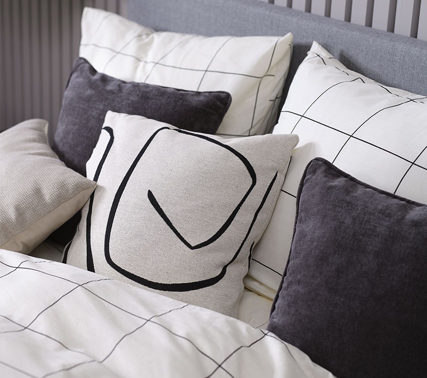 Sypialnia z biało czarnym kompletem pościeli i poduszkami ozdobnymi 