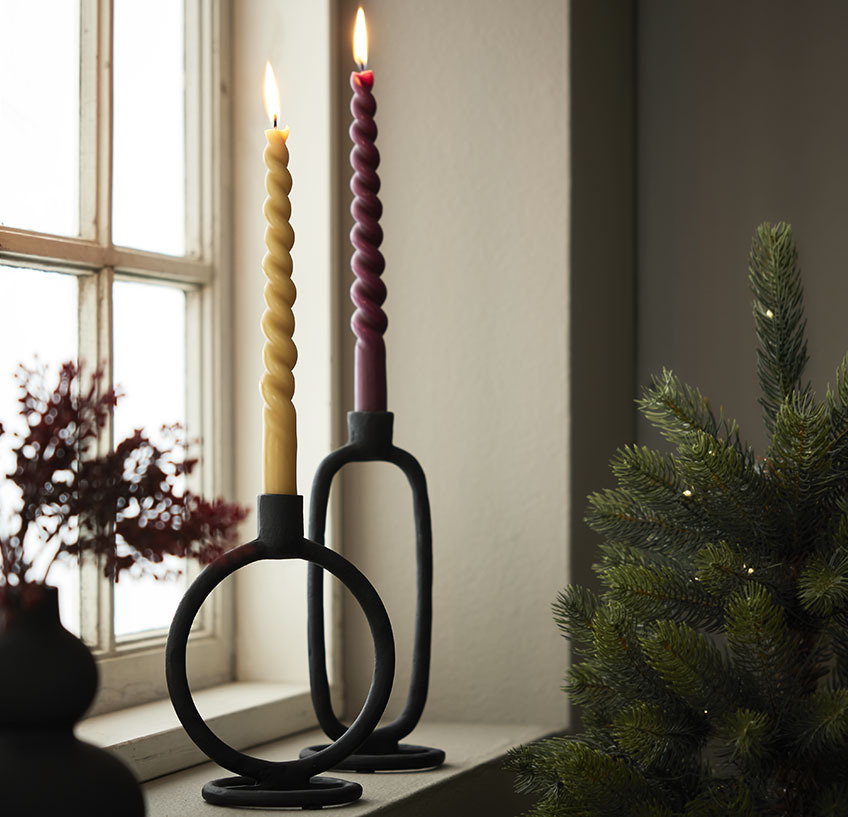 świeczki ADVENT i świecznik ELDARIT. Parapet, na którym stoją dwa czarne świeczniki ze złotą i bordową świeczką.