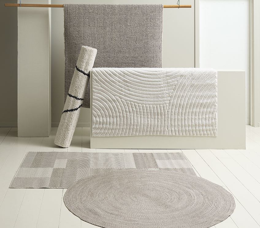 okrągły dywan wewnętrzno – zewnętrzny położony na prostokątnych dywanach w naturalnych kolorach