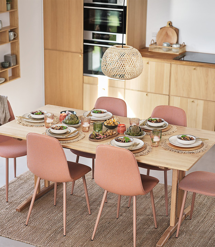Stół w jadalni z drewnianym blatem i jasnoróżowymi krzesłami 