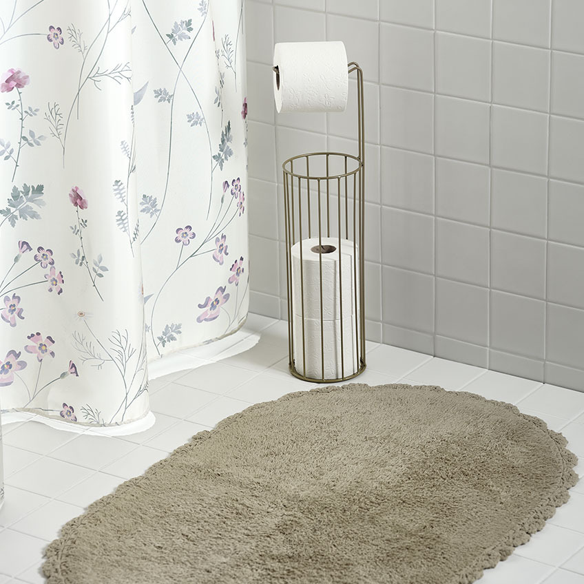 Zasłona prysznicowa, mata łazienkowa i stojak na papier toaletowy w łazience